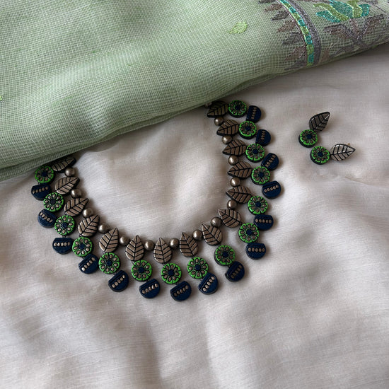 Handmade green and navy blue terracotta necklace set with leaf, floral, and geometric motifs.