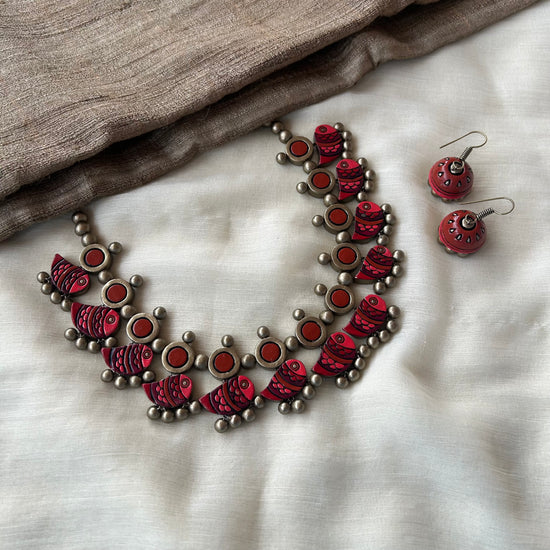 Handmade red terracotta necklace set with fish motifs and circular accents.