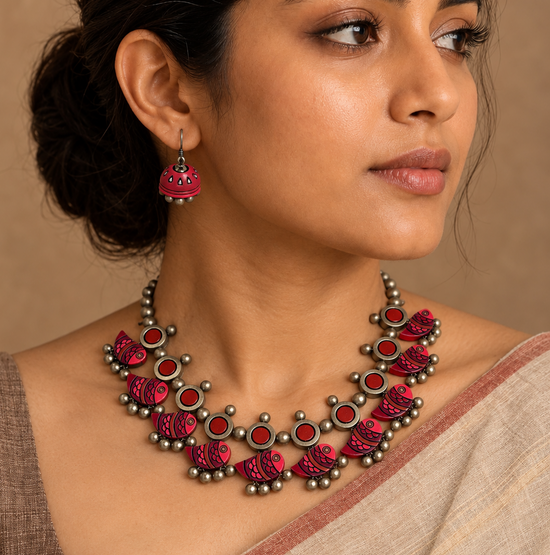 Handmade red terracotta necklace set with fish motifs and circular accents.