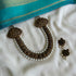A set of handcrafted terracotta jewelry including a beaded necklace with gold shades and studs, and matching earrings, displayed on a white fabric backdrop.